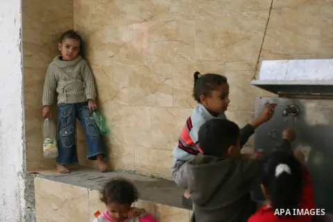 Palestinian children fill plastic bottles with drinking water in Rafah camp southern Gaza Strip, on Dec. 30, 2012. The residents of the Gaza strip suffer from lack of potable water, Israel continues to tighten its blocka...