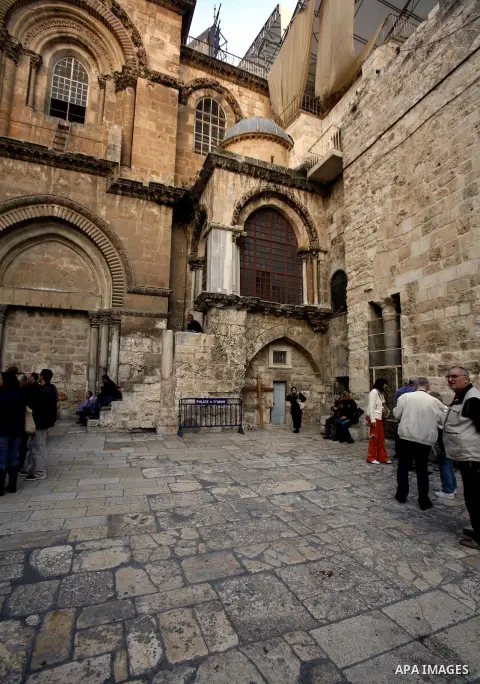Palestinian and foreign worshippers walk outside the church of the Holy Sepulchre in Jerusalem's old city on December 30, 2012. The church has been a paramount - and for many Christians the most important - pilgrimage de...