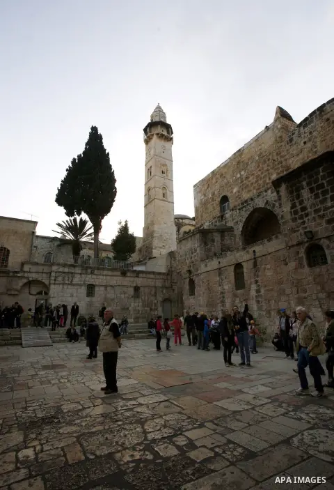 Palestinian and foreign worshippers walk outside the church of the Holy Sepulchre in Jerusalem's old city on December 30, 2012. The church has been a paramount - and for many Christians the most important - pilgrimage de...