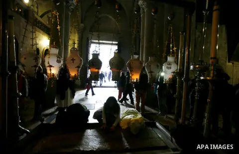 Palestinian and foreign worshippers pray at the church of the Holy Sepulchre in Jerusalem's old city on December 30, 2012. The church has been a paramount - and for many Christians the most important - pilgrimage destina...