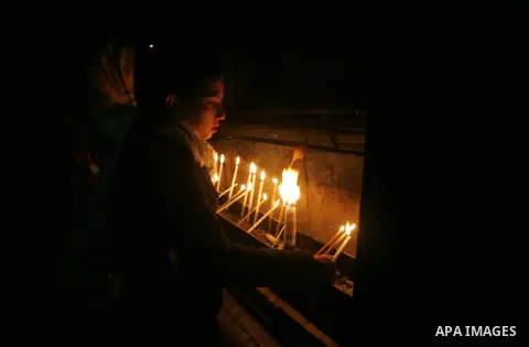 Palestinian worshippers set a candles at the church of the Holy Sepulchre in Jerusalem's old city on December 30, 2012. The church has been a paramount - and for many Christians the most important - pilgrimage destinatio...