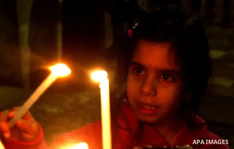 A Palestinian girl sets a candle at the church of the Holy Sepulchre in Jerusalem's old city on December 30, 2012. The church has been a paramount - and for many Christians the most important - pilgrimage destination sin...