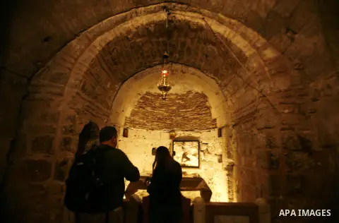 Palestinian and foreign worshippers walk outside the church of the Holy Sepulchre in Jerusalem's old city on December 30, 2012. The church has been a paramount - and for many Christians the most important - pilgrimage de...
