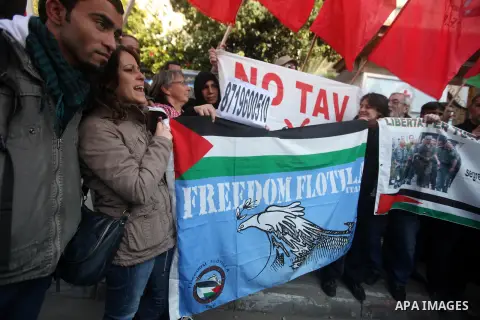 Palestinians and foreign protesters hold pictures of prisoners held in the Israeli jails during a rally in Gaza city on December 31, 2012. in solidarity with hunger-striking detainees held by Israel to demand their relea...