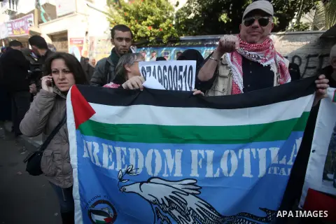 Palestinians and foreign protesters hold pictures of prisoners held in the Israeli jails during a rally in Gaza city on December 31, 2012. in solidarity with hunger-striking detainees held by Israel to demand their relea...