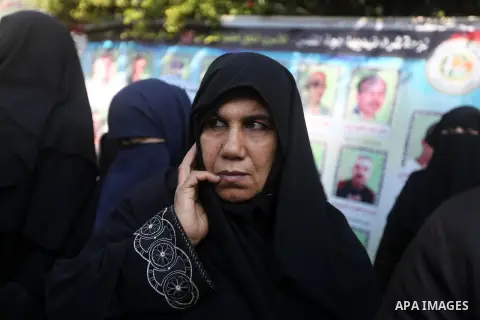 Palestinians hold pictures of prisoners held in the Israeli jails during a rally in Gaza city on December 31, 2012. in solidarity with hunger-striking detainees held by Israel to demand their release from detention witho...