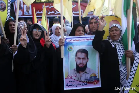 Palestinians hold pictures of prisoners held in the Israeli jails during a rally in Gaza city on December 31, 2012. in solidarity with hunger-striking detainees held by Israel to demand their release from detention witho...