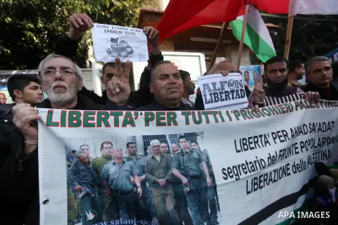 Palestinians and foreign protesters hold pictures of prisoners held in the Israeli jails during a rally in Gaza city on December 31, 2012. in solidarity with hunger-striking detainees held by Israel to demand their relea...