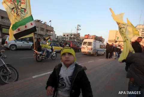 Palestinians ride a motorcycle and carry the Fatah party's flag and the Syrian revolution flag during a rally in Gaza city on December 31, 2012. The Gaza branch of Palestinian president Mahmud Abbas's Fatah party said on...