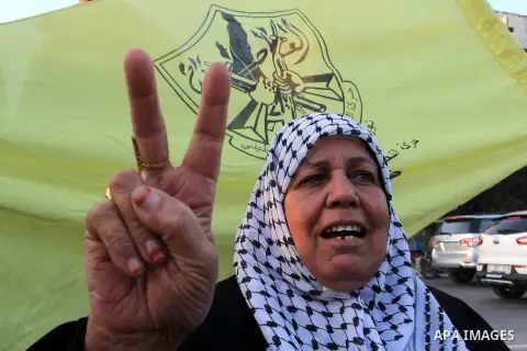 A Palestinian woman marks victory sign during a rally in Gaza city on December 31, 2012. The Gaza branch of Palestinian president Mahmud Abbas's Fatah party said on Friday it will mark its anniversary in the Hamas-ruled...