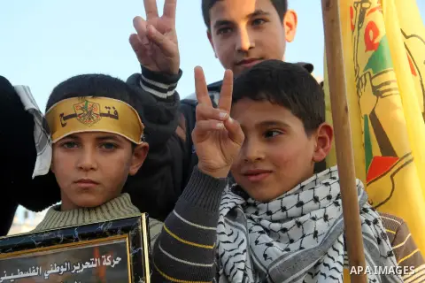 Palestinian children mark victory sign during a rally in Gaza city on December 31, 2012. The Gaza branch of Palestinian president Mahmud Abbas's Fatah party said on Friday it will mark its anniversary in the Hamas-ruled...