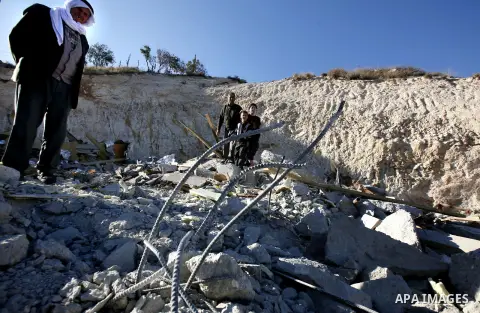 Palestinians search in the rubble of their house after it was demolished by Jerusalem municipality workers in the east Jerusalem on December 21, 2012. Palestinian homes built without a construction permit are often demol...