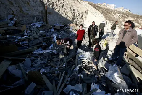 Palestinians search in the rubble of their house after it was demolished by Jerusalem municipality workers in the east Jerusalem on December 21, 2012. Palestinian homes built without a construction permit are often demol...