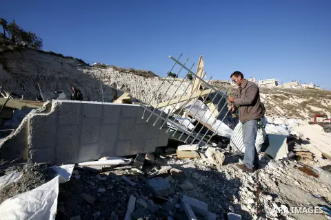 Palestinians search in the rubble of their house after it was demolished by Jerusalem municipality workers in the east Jerusalem on December 21, 2012. Palestinian homes built without a construction permit are often demol...