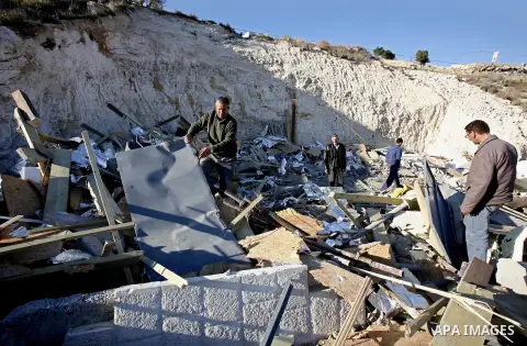 Palestinians search in the rubble of their house after it was demolished by Jerusalem municipality workers in the east Jerusalem on December 21, 2012. Palestinian homes built without a construction permit are often demol...
