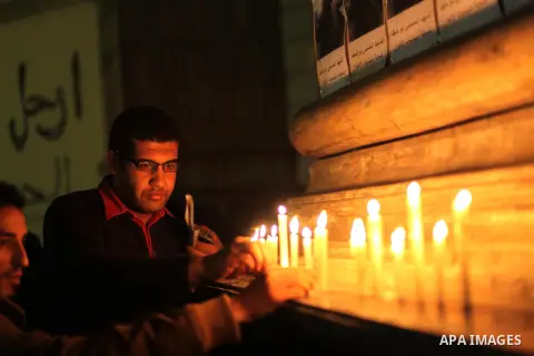 Egyptian activists light candles at the entrance of the Journalist's Syndicate in Cairo on December 31, 2012, during a rally to commemorate the anniversary of the car bomb attack on the al-Qiddissine (The Saints) church...