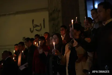 Egyptian activists hold candles as they take part in a rally on the anniversary of the attack on the All Saints Church (al-Qiddissine) in the city of Alexandria two years ago, as the gather on new Year's eve in front of...