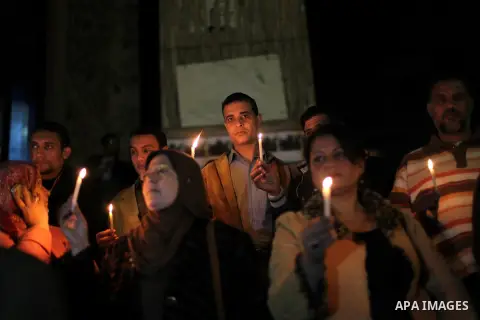 Egyptian activists hold candles as they take part in a rally on the anniversary of the attack on the All Saints Church (al-Qiddissine) in the city of Alexandria two years ago, as the gather on new Year's eve in front of...