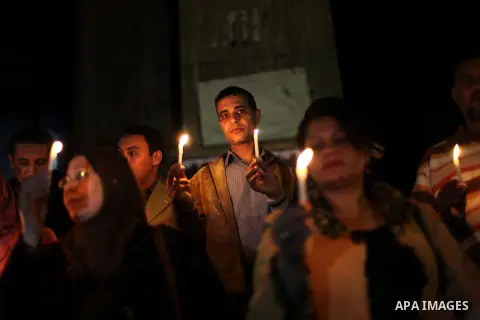 Egyptian activists hold candles as they take part in a rally on the anniversary of the attack on the All Saints Church (al-Qiddissine) in the city of Alexandria two years ago, as the gather on new Year's eve in front of...