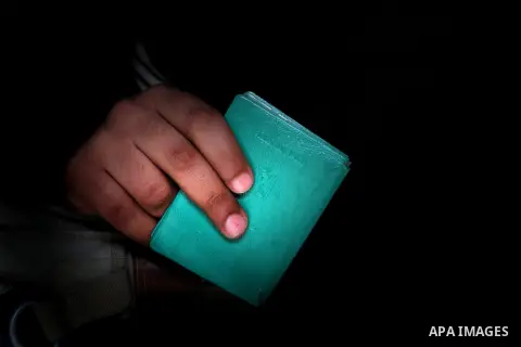 A Palestinian man carries his ID to update his details at a centre run by the Palestinian Central Election Commission (CEC), in Gaza city on February 12, 2013. The Palestinian Central Election Commission (CEC) began on M...