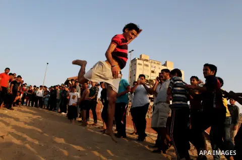 Palestinian boys enjoy playing in the sea at Gaza beach during hot weather in Gaza city, May 03, 2013. Gazans escape to the beach and out from their homes during heat wave and power outages. Photo by Emad Nassar