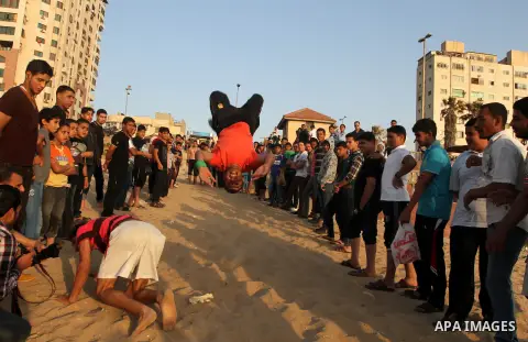 Palestinian children enjoy playing in the sea at Gaza beach during hot weather in Gaza city, May 03, 2013. Gazans escape to the beach and out from their homes during heat wave and power outages. Photo by Emad Nassar