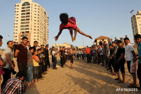 Palestinian boys enjoy playing in the sea at Gaza beach during hot weather in Gaza city, May 03, 2013. Gazans escape to the beach and out from their homes during heat wave and power outages. Photo by Emad Nassar