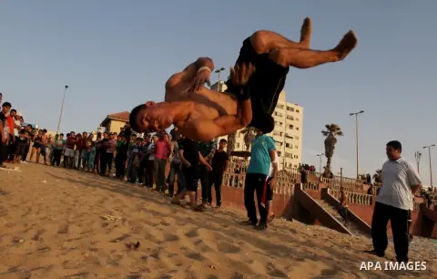 Palestinian boys enjoy playing in the sea at Gaza beach during hot weather in Gaza city, May 03, 2013. Gazans escape to the beach and out from their homes during heat wave and power outages. Photo by Emad Nassar