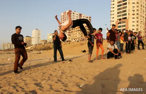 Palestinian boys enjoy playing in the sea at Gaza beach during hot weather in Gaza city, May 03, 2013. Gazans escape to the beach and out from their homes during heat wave and power outages. Photo by Emad Nassar