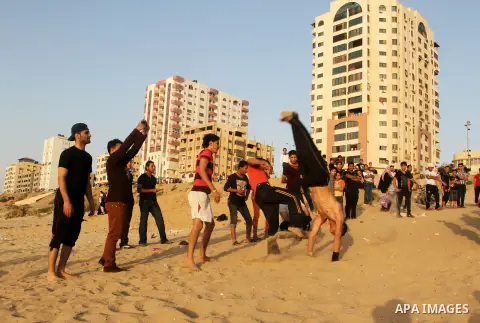 Palestinian boys enjoy playing in the sea at Gaza beach during hot weather in Gaza city, May 03, 2013. Gazans escape to the beach and out from their homes during heat wave and power outages. Photo by Emad Nassar