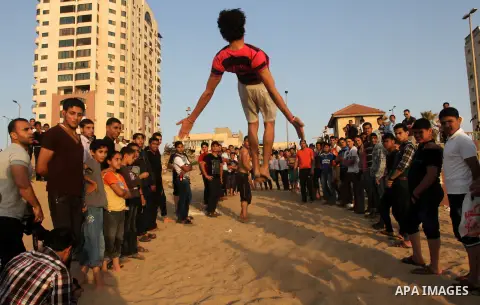 Palestinian boys enjoy playing in the sea at Gaza beach during hot weather in Gaza city, May 03, 2013. Gazans escape to the beach and out from their homes during heat wave and power outages. Photo by Naaman Omar
