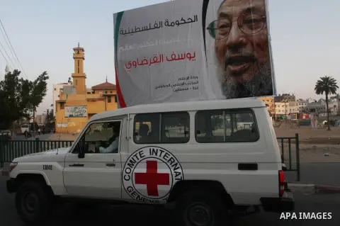 A car is driven past a banner with picture of prominent Muslim scholar Sheikh Yusuf al-Qaradawi, in Gaza city on May 07, 2013. Al-Qaradawi, Qatar-based cleric who is widely-respected through the Muslim world, and undersc...
