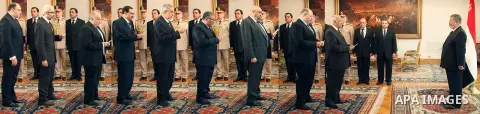 Egyptian President Mohamed Morsi poses for a group picture with the Prime Minister Hisham Qandil and cabinet ministers during a meeting in Cairo, Egypt, May 7, 2013. Egyptian President Mohamed Morsi swore in nine new min...