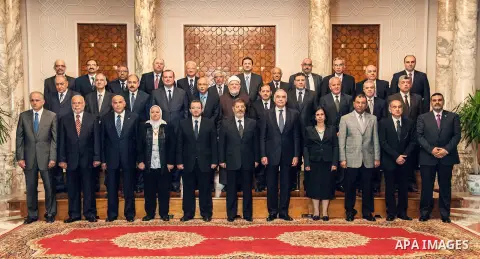 Egyptian President Mohamed Morsi poses for a group picture with the Prime Minister Hisham Qandil and cabinet ministers during a meeting in Cairo, Egypt, May 7, 2013. Egyptian President Mohamed Morsi swore in nine new min...