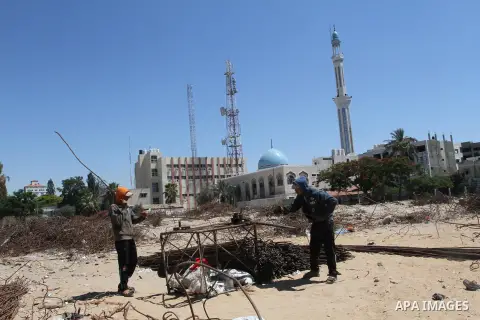 Palestinian laborers adjust used steel bars, at a site of an old prison known as al-Saraya that was destroyed by the Isreali airstrikes during the conflict between Israel and Gaza militants, in Gaza city July 4, 2013. Pa...