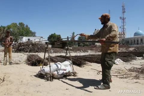 Palestinian laborers adjust used steel bars, at a site of an old prison known as al-Saraya that was destroyed by the Isreali airstrikes during the conflict between Israel and Gaza militants, in Gaza city July 4, 2013. Pa...