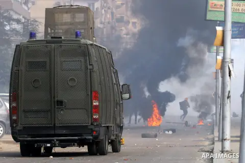 Egyptian anti-riot police forces advance amid smoke and burning objects allegedly set on fire by supporters of the Muslim Brotherhood during clashes in Cairo on January 3, 2014. The protests came after an Islamist allian...