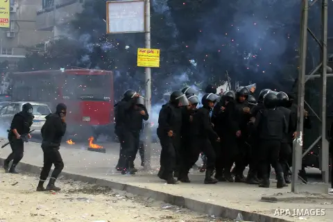 Egyptian anti-riot police forces advance amid smoke and burning objects allegedly set on fire by supporters of the Muslim Brotherhood during clashes in Cairo on January 3, 2014. The protests came after an Islamist allian...