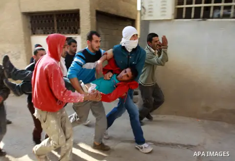 Palestinian stone-throwers carry an injured man during clashes in the West Bank village of Tamoun, near Jenin, Tuesday, Jan. 1, 2013. Palestinians say a raid by Israeli soldiers disguised as vegetable vendors to seize me...