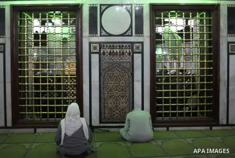 Egyptian Muslims pray at a tomb in al-Hussein mosque, which according to the belief head of Imam Hussein, the grandson of prophet Mohammed, is buried, in the old city of Cairo on Jan. 1, 2013. Photo by Ashraf Amra