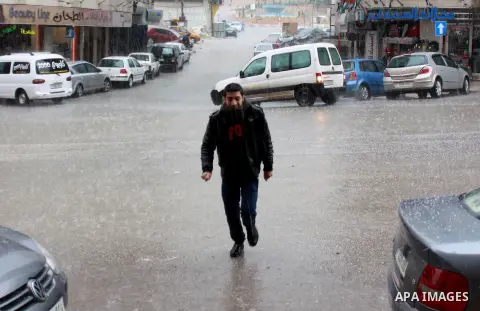 A Palestinian man walks in a street during the fall of rains in the West Bank city of Nablus, on a windy winter day in West Bank January 7, 2013. Photo by Nedal Eshtayah