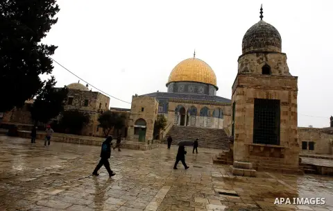 Palestinians walk in the grounds of the Al-Aqsa Mosque compound, in Jerusalem's old city, on January 9, 2013. as a snow storm rolls into the city with waves of sleet, hail and high winds. Photo by Mahfouz Abu Turk