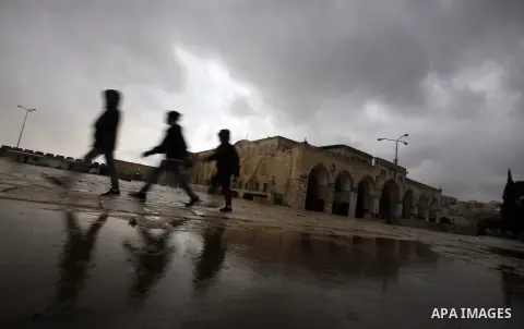 Palestinians walk in the grounds of the Al-Aqsa Mosque compound, in Jerusalem's old city, on January 9, 2013. as a snow storm rolls into the city with waves of sleet, hail and high winds. Photo by Mahfouz Abu Turk