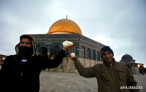 Palestinians play with snow, in Jerusalem's old city, on January 9, 2013. as a snow storm rolls into the city with waves of sleet, hail and high winds. Photo by Mahfouz Abu Turk