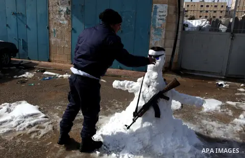 A Palestinian policeman builds a snowman in the West Bank city of Ramallah January 10, 2013. At least 17 people have died due to a storm in Lebanon, Jordan, Turkey, Israel and the Palestinian territories. Meteorological...