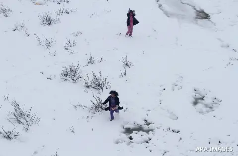 Palestinians play in the snow in the West Bank city of Ramallah January 10, 2013. At least 17 people have died due to a storm in Lebanon, Jordan, Turkey, Israel and the Palestinian territories. Meteorological agencies in...
