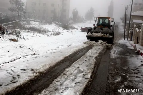 Bulldozers clear the tracks of snow in the West Bank city of Ramallah January 10, 2013. At least 17 people have died due to a storm in Lebanon, Jordan, Turkey, Israel and the Palestinian territories. Meteorological agenc...