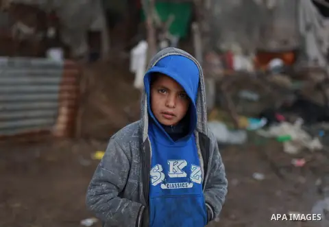 A Palestinian bedouin child stands outside his shack on a windy winter day in the central Gaza Strip January 10, 2013. A storm has hit the eastern Mediterranean coast and heavy rains with flooding are forecast in Israel...