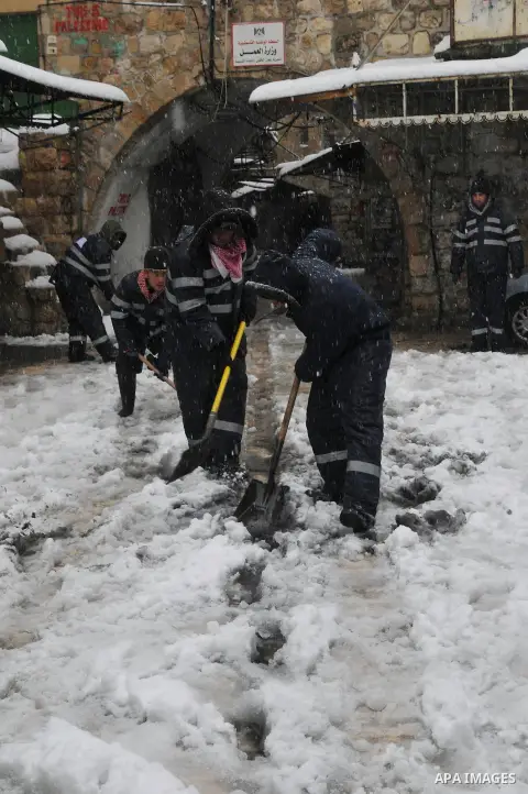 Palestinian security shovels snow outside of the Ibrahami Mosque or the Tomb of the Patriarchs in the West Bank City of Hebron as wintry weather swept through the region 10 January 2013. Photo by Mamoun Wazwaz