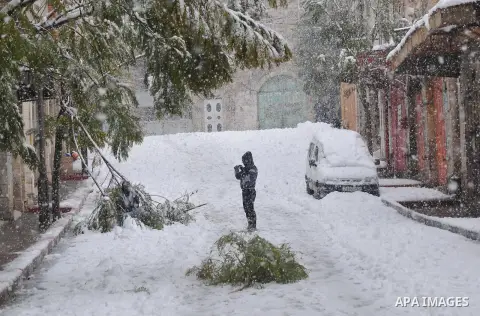 A Palestinian boy plays with snow balls after heavy snow falls on January 10, 2013 in Tuqua, near the West Bank City of Hebron 10 January 2013. The higher elevations in the Palestinian Authority areas and Israel, includi...